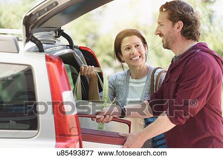 Couple packing their car View Large Photo Image Stock Photo - Couple packing their car. Fotosearch