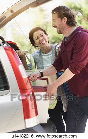Couple packing their car View Large Photo Image Stock Photograph - Couple packing their car. Fotosearch