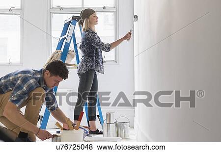 Couple painting room white View Large Photo Image Stock Photo - Couple painting room white. Fotosearch