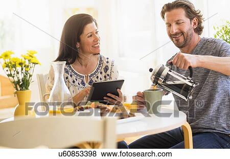 Couple talking at table View Large Photo Image Stock Photo - Couple talking at table. Fotosearch
