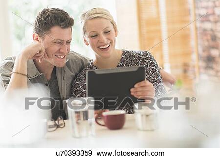 Couple using tablet pc in cafe View Large Photo Image Stock Photo - Couple using tablet pc in cafe. Fotosearch