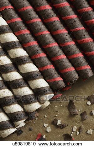 Stock Image - Detail of Italian rolled wafer cookies and crumbs on baking paper. Fotosearch