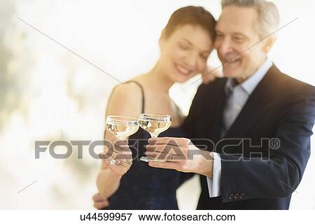 Stock Photo - Elegant senior couple celebrating their anniversary with champagne toast. Fotosearch