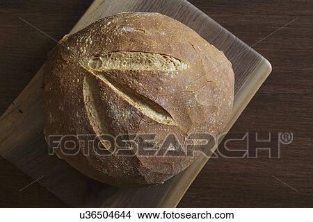 Picture - Fresh baked bread on cutting board. Fotosearch