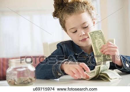 Picture - Girl (10-11) counting her savings. Fotosearch