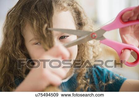 Stock Photo - Girl (10-11) cutting her hair. Fotosearch