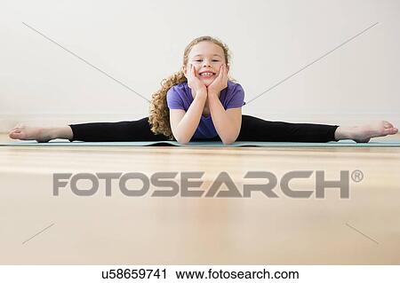 Stock Image - Girl (10-11) doing splits. Fotosearch