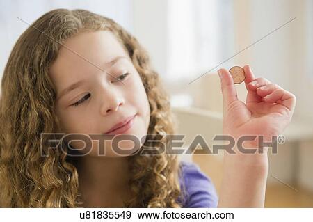 Stock Photo - Girl (10-11) holding coin. Fotosearch
