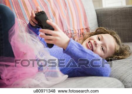 Girl (10-11) wearing tutu playing video game View Large Photo Image Stock Photo - Girl (10-11) wearing tutu playing video game. Fotosearch