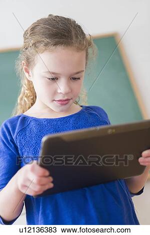 Girl (10-11) with tablet in classroom View Large Photo Image Stock Image - Girl (10-11) with tablet in classroom. Fotosearch