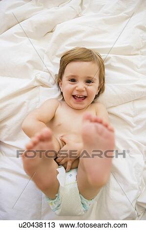 Stock Image - Girl (2-3) lying on bed. Fotosearch