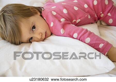 Girl (2-3) lying on bed View Large Photo Image Stock Image - Girl (2-3) lying on bed. Fotosearch