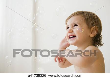 Stock Photograph - Girl (2-3) playing with bubbles. Fotosearch