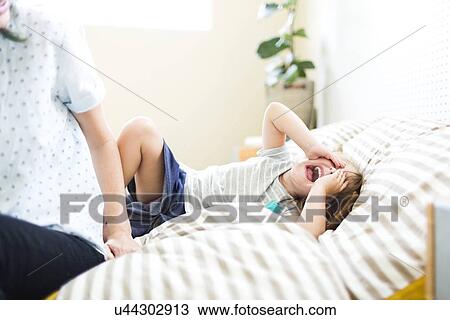 Girl (4-5) lying on bed with open mouth and covering face View Large Photo Image Stock Image - Girl (4-5) lying on bed with open mouth and covering face. Fotosearch
