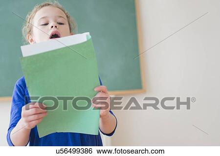 Girl reading in front of chalkboard View Large Photo Image Stock Photograph - Girl reading in front of chalkboard. Fotosearch