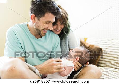 Happy parents looking at baby boy (6-11 months) View Large Photo Image Stock Photo - Happy parents looking at baby boy (6-11 months). Fotosearch
