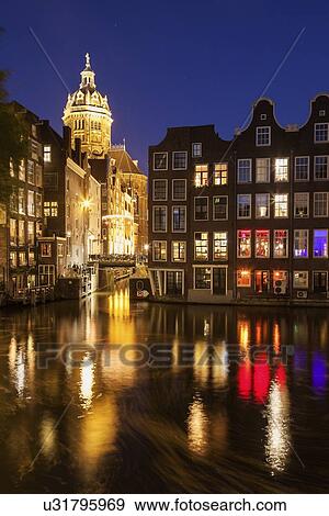 Stock Photo - Illuminated buildings by canal at night. Fotosearch