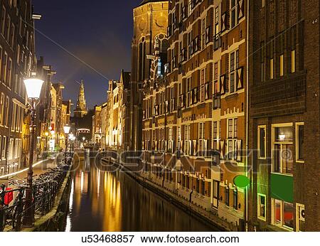 Illuminated buildings by canal at night View Large Photo Image Stock Photo - Illuminated buildings by canal at night. Fotosearch