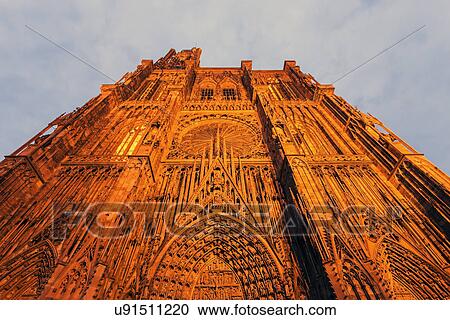 Stock Image - Illuminated facade of Strasbourg Minster against sky. Fotosearch