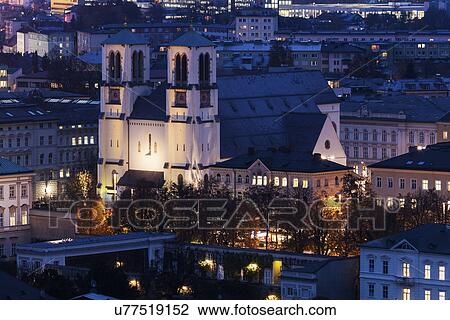 Stock Image - Illuminated St. Andrew's Church and surrounding cityscape . Fotosearch
