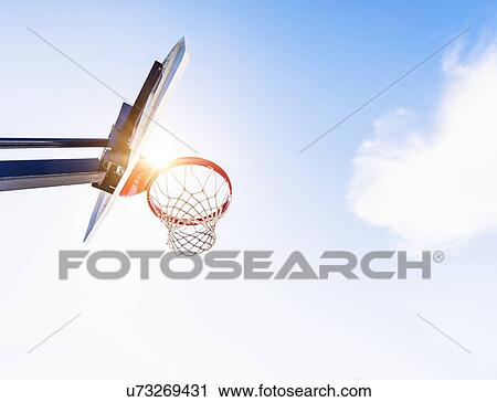 Stock Image - Low-angle view of basketball hoop. Fotosearch