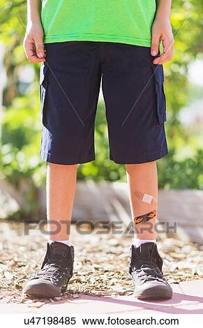 Low-section of boy (8-9) with bandages on legs View Large Photo Image Stock Photography - Low-section of boy (8-9) with bandages on legs. Fotosearch