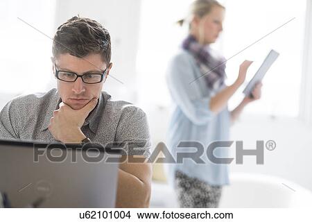 Picture - Man and woman working in office. Fotosearch