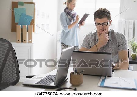 Picture - Man and woman working in office. Fotosearch