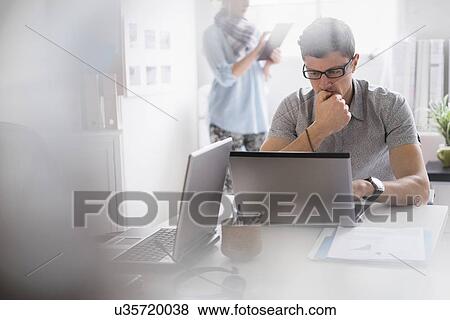 Stock Photo - Man and woman working in office. Fotosearch