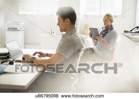 Stock Photo - Man and woman working in office. Fotosearch