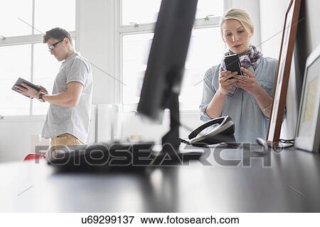Stock Photo - Man and woman working in office. Fotosearch