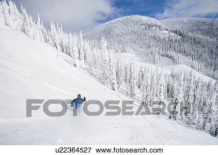 Stock Photo - Man skiing down mountain. Fotosearch