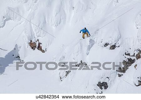 Man snowboarding down mountain View Large Photo Image Picture - Man snowboarding down mountain. Fotosearch
