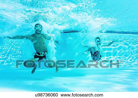 Stock Image - Man swimming with his brother (8-9). Fotosearch