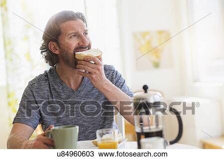 Stock Image - Mature man eating breakfast. Fotosearch