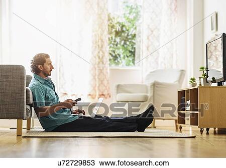 Stock Image - Mature man watching tv. Fotosearch