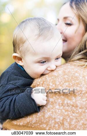 Mother carrying baby boy (6-11 months) View Large Photo Image Stock Photo - Mother carrying baby boy (6-11 months). Fotosearch