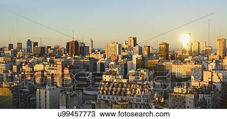 Stock Image - Panoramic view of cityscape at dusk. Fotosearch