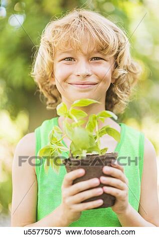 Portrait of boy (8-9) holding potted plant View Large Photo Image Stock Photography - Portrait of boy (8-9) holding potted plant. Fotosearch