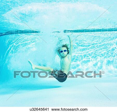 Stock Image - Portrait of boy (8-9) in swimming pool. Fotosearch