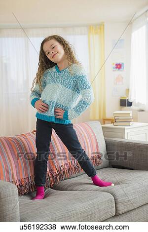 Portrait of girl (10-11) posing on sofa View Large Photo Image Stock Photo - Portrait of girl (10-11) posing on sofa. Fotosearch