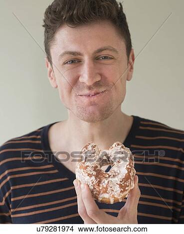 Portrait of man eating donut View Large Photo Image Picture - Portrait of man eating donut. Fotosearch