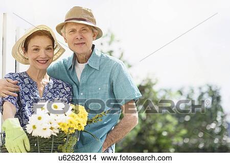 Portrait of smiling senior couple with flowers View Large Photo Image Picture - Portrait of smiling senior couple with flowers. Fotosearch