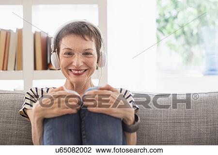 Stock Image - Portrait of smiling senior woman with headphones. Fotosearch