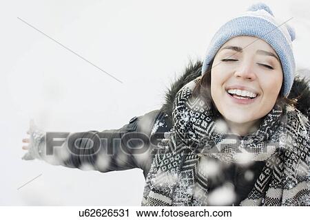 Stock Image - Portrait of smiling woman in snow. Fotosearch