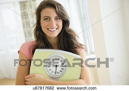 Portrait of woman holding scale View Large Photo Image Stock Image - Portrait of woman holding scale. Fotosearch