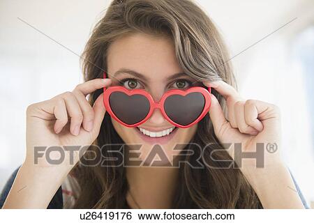 Stock Photograph - Portrait of woman in heartshaped sunglasses. Fotosearch