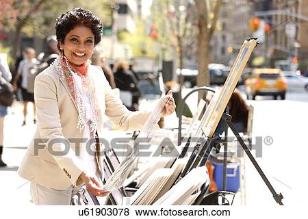 Stock Photo - Portrait of woman watching art on street. Fotosearch