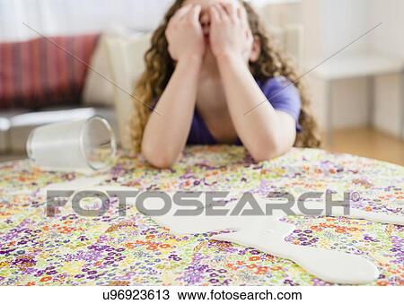 Stock Image - Sad girl (10-11) spilled out milk. Fotosearch