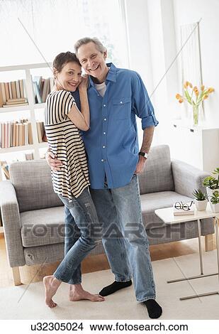 Senior couple embracing in living room View Large Photo Image Picture - Senior couple embracing in living room. Fotosearch